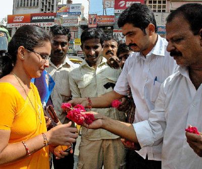Praja Rajyam Party leaders and workers distributing flowers to people at Sankar Vilas Centre in Guntur on Wednesday.